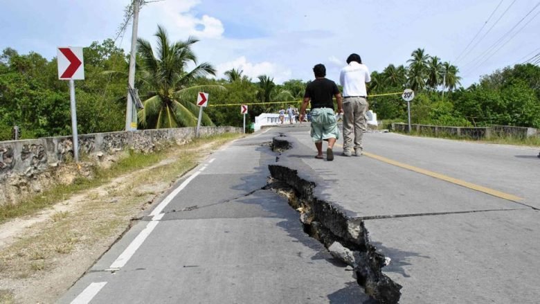 Residents walk along huge cracks in a road after an earthquake struck Bohol province, central Philippines