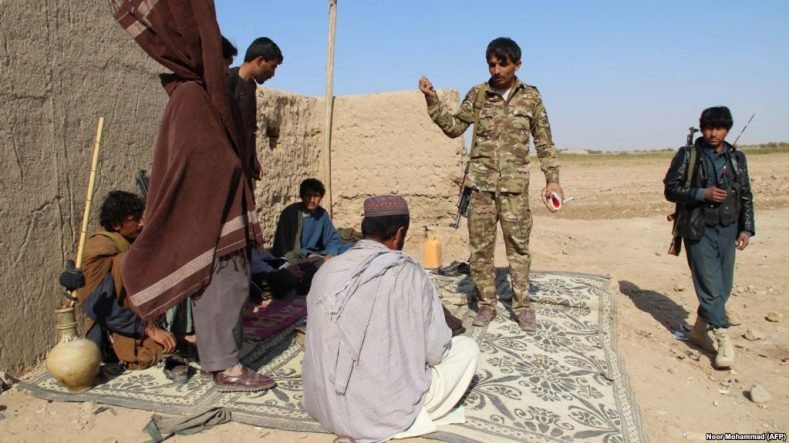 Afghan Local Police officers stand at a checkpoint in Helmand