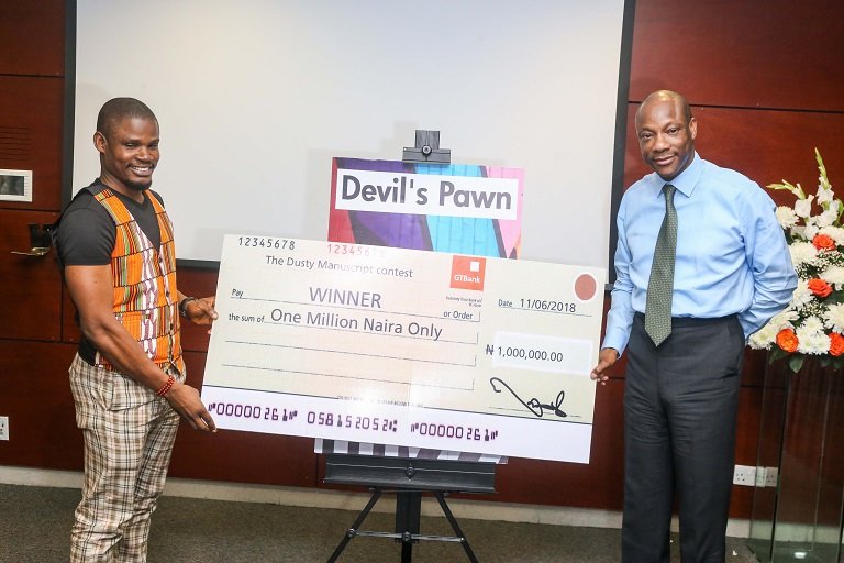 Kukogho Iruesiri Samson who wrote Devil's Pawn presented with a one million naira cheque by Segun Agbaje, GTB MD/CEO