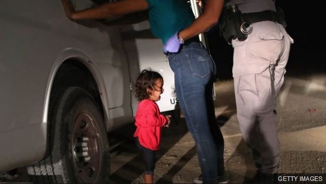 US immigration officer separating a child from her mother following Trump's zero tolerance policy