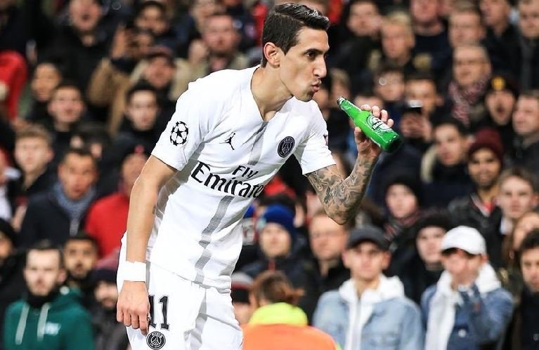 Angel di Maria reacts to jeers of Man Utd fans by faking to drink a beer thrown at him during the game