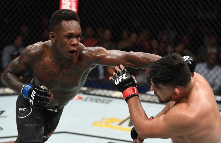 Israel Adesanya lands a combination of punches to the face of Kevin Gastelum to win the interim UFC middleweight belt