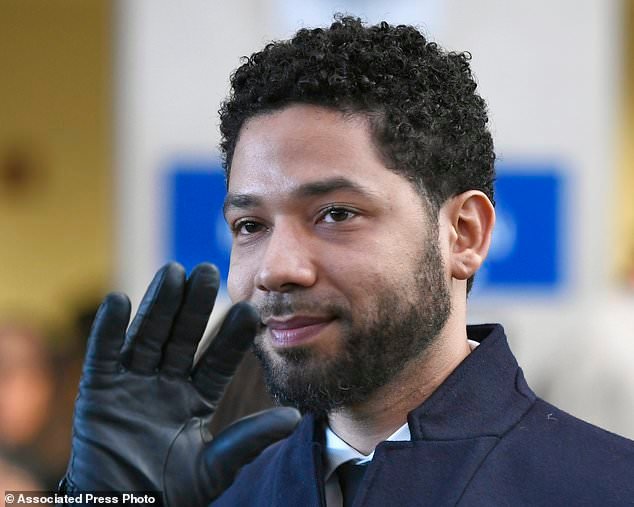 Jussie Smollett smiles and waves to supporters before leaving Cook County Court after his charges were dropped in Chicago