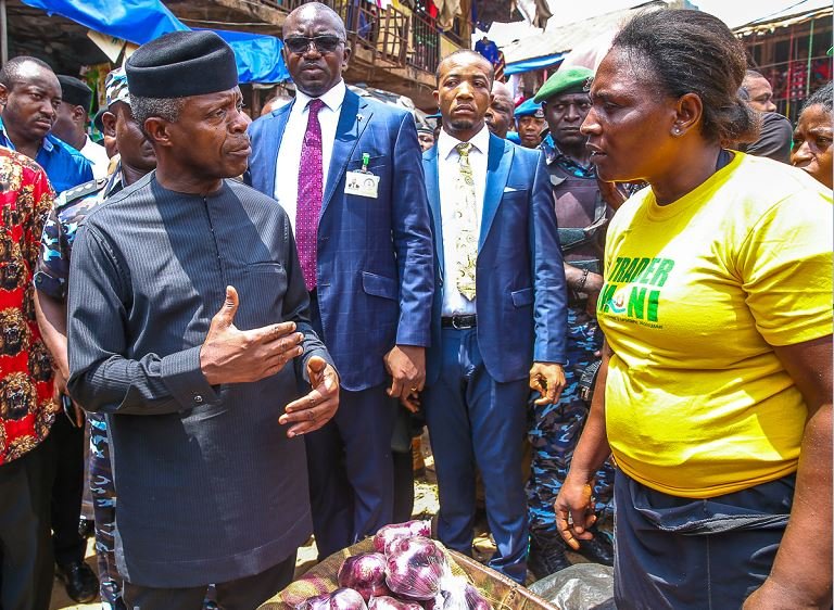 Vice President Yemi Osinbajo interacts with a petty trader in Onitsha, Anambra State