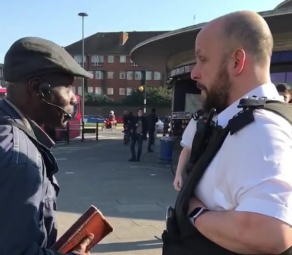 Ilesanmi Oluwole talking to a Met police officer before he was arrested
