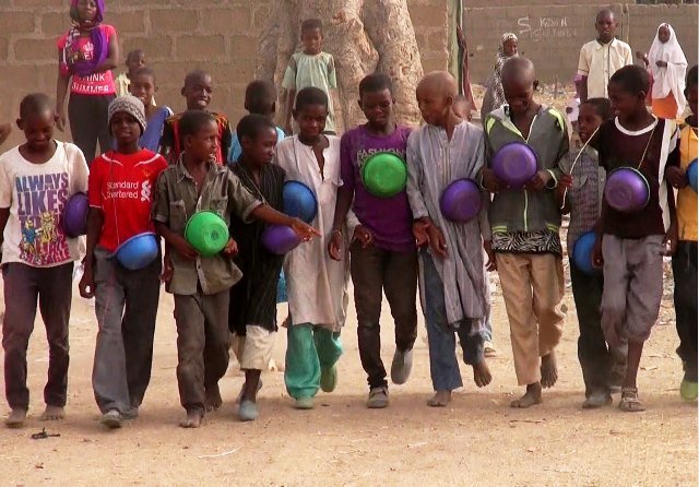 Some Nigerian children begging for alms with bowl in their hands