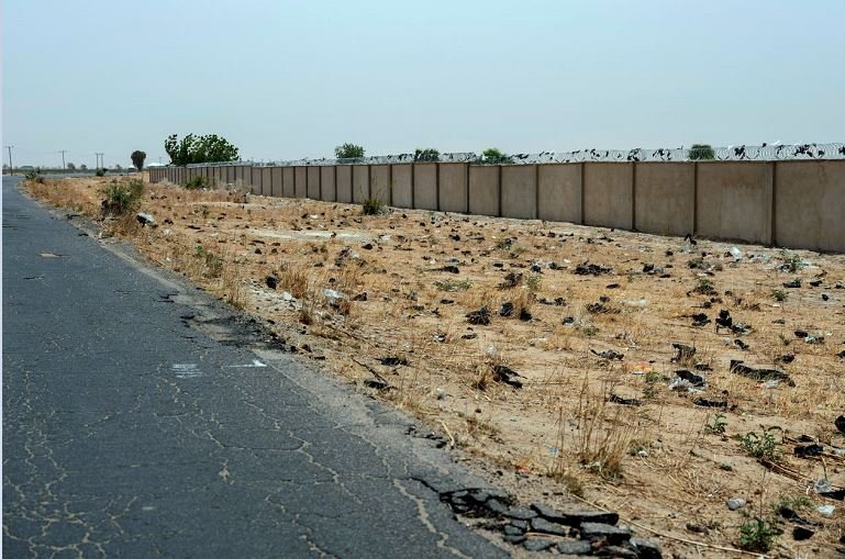 Nigeria’s military built this barrier to wall off what had been farmland on the northern edge of the base in Maiduguri. An expanding cemetery lies on the other side.