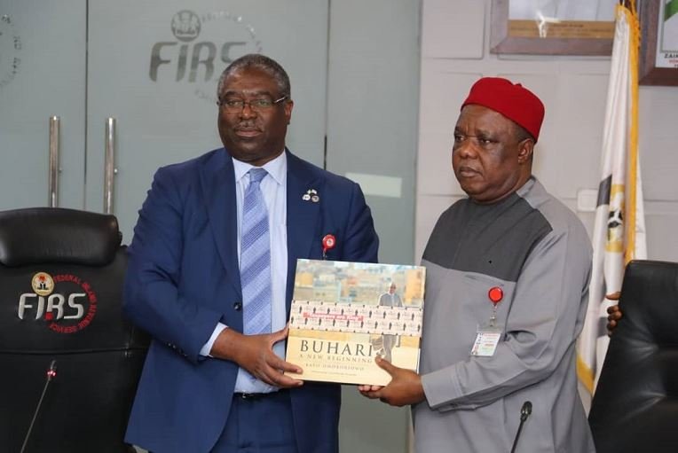 Chairman, Federal Inland Revenue Service (FIRS), Mr. Tunde Fowler, presenting a book on President Muhammadu Buhari to Chairman, Revenue Mobilisation, Allocation and Fiscal Commission (RMAFC), Chief Elias Mbam at the FIRS Headquarters in Abuja