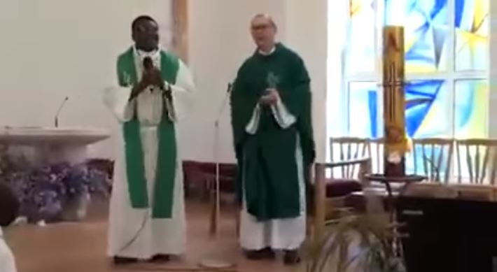 An African minister appears to be teaching the church and the choir Imela, Imela, an Igbo song