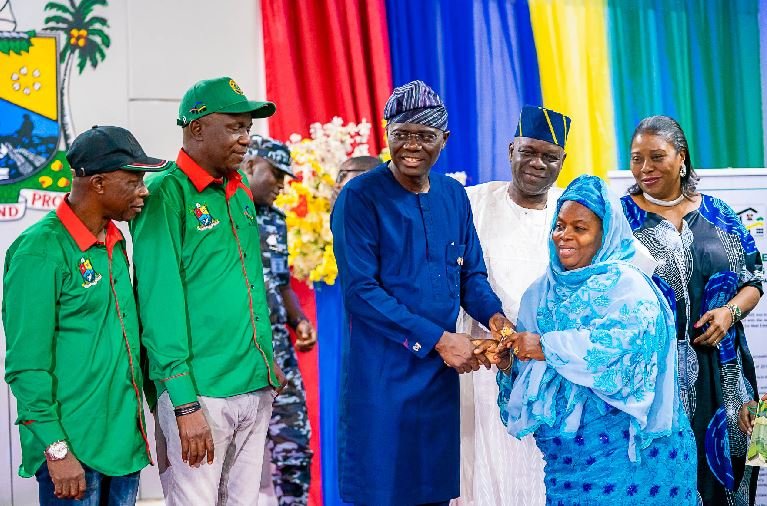 Lagos State Governor, Mr. Babajide Sanwo-Olu (middle) presenting keys to an allottee, Mrs. Fatima Kosoko