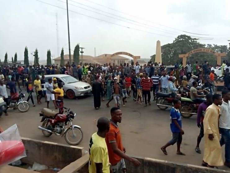 Protesters walk past the palace of the Akarigbo of Remo in Sagamu, Ogun State on Monday