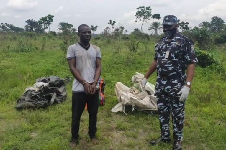 Police with the suspect who killed three UNIPORT students standing in front of their body bags