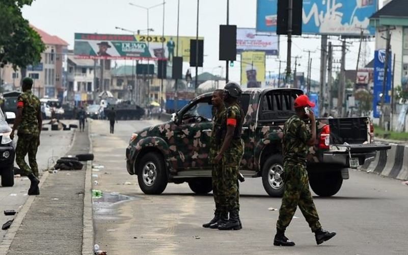 Nigerian soldiers condone a street to restore normalcy