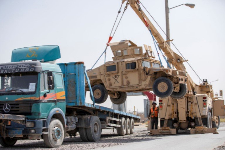 U.S. Army soldiers and contractors load High Mobility Multi-purposed Wheeled Vehicles, HUMVs, to be sent for transport as U.S. forces prepare for withdrawl, in Kandahar, Afghanistan
