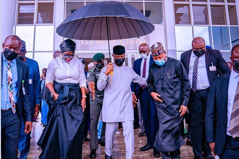 Vice President Yemi Osinbajo holds an umbrella over his head and that of HMS Science & Tech Mohammed Abdullahi and Senator Ekwunife as they depart Musa Yaradua Center after he launched National Leather and Leather Products Policy Implementation Plan at the Musa Yaradua Centre in Abuja