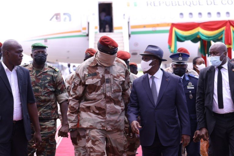 Ivory Coast's President Alassane Ouattara walks with Special forces commander Mamady Doumbouya, who ousted President Alpha Conde upon his arrival to discuss ways to return the country to constitutional in Conakry, Guinea