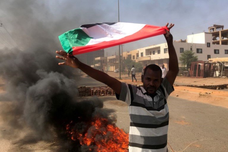 Chad, A protester waves a flag during what the information ministry calls a military coup in Khartoum, Sudan