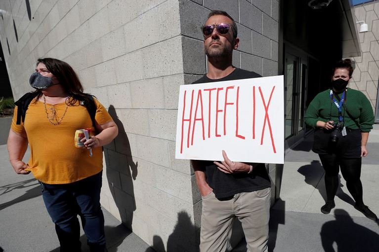 A man holds a placard as he attends a rally in support of the Netflix transgender employee walkout "Stand Up in Solidarity" to protest the streaming of comedian Dave Chappelle's new comedy special, in Los Angeles, California, U.S