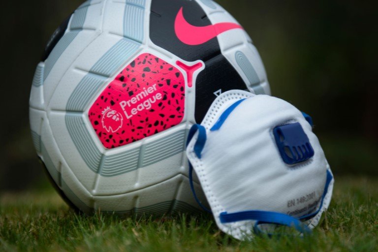 Premier League football beside a face mask