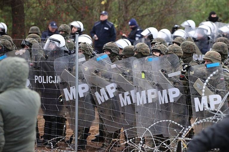 Polish troops and border guards with shields stopped migrants from crossing into the country
