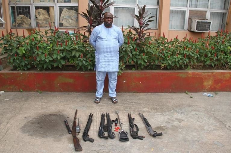 Bolarinwa Oluwasegun poses with the arms recovered from him