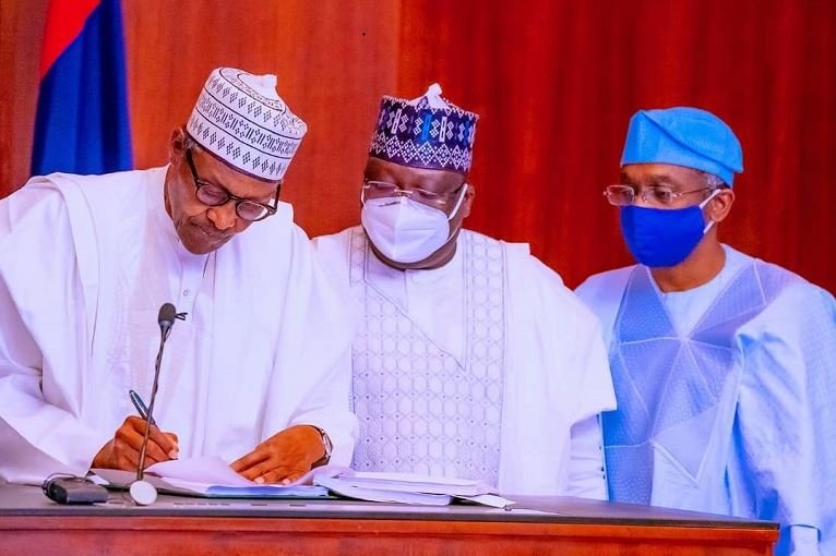 President Muhammadu Buhari signs the Electoral Act as Senate President Ahmad Lawan and Speaker Femi Gbajabiamila look on Electoral Act