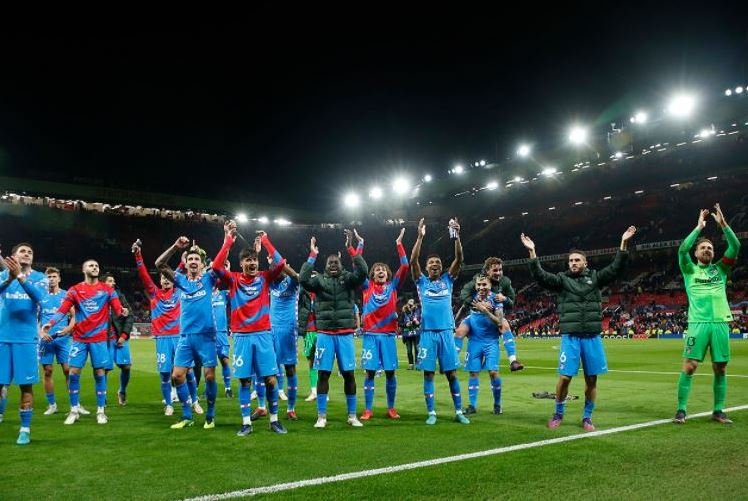 Atletico Madrid players celebrate with the away fans after their victory at Old Trafford