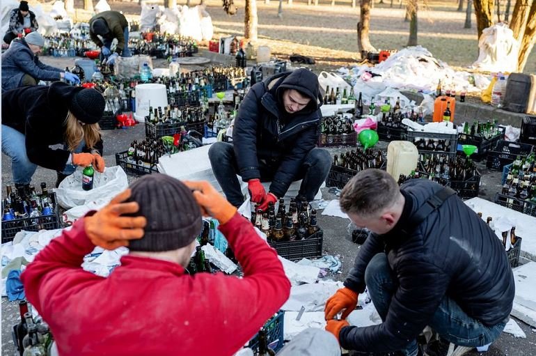 Local residents prepare Molotov cocktails, as Russia's invasion of Ukraine continues, to defend their city, in Zhytomyr, Ukraine