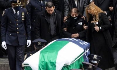 Family members at the funeral of Wilbert Mora, an NYPD officer killed by a suspect in January