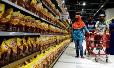 People shop for cooking oil made from oil palms at a supermarket in Jakarta, Indonesia