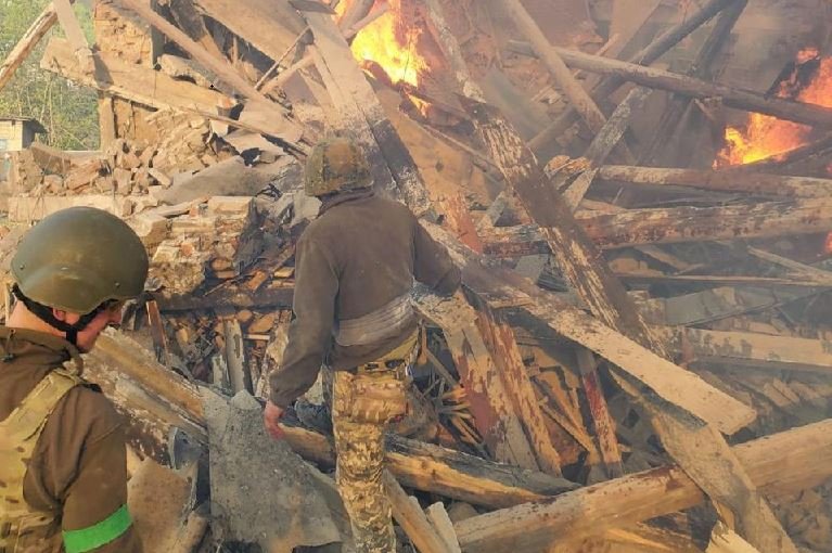 Emergency crew work near a burning debris, after a school building was hit as a result of shelling, in the village of Bilohorivka, Luhansk, Ukraine