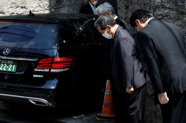 LDP officials pray to the vehicle believed to be carrying the body of former Japanese Prime Minister Shinzo Abe, who was shot while campaigning for a parliamentary election, at his residence in Tokyo, Japan