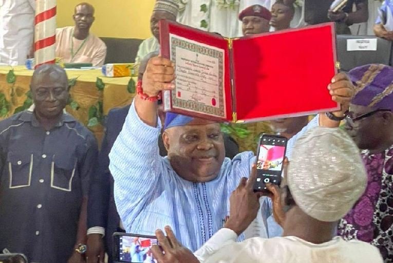 Senator Ademola Adeleke shows off the Certificate of Return