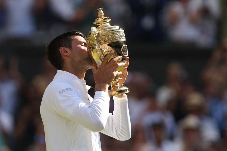 Serbia's Novak Djokovic celebrates with the trophy after winning the men's singles final against Australia's Nick Kyrgios