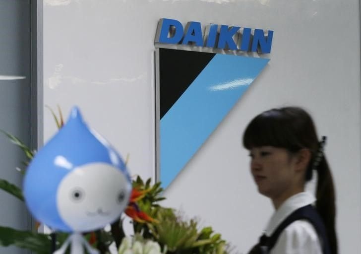 A staff walks past a logo of Daikin Industries Ltd and the company mascot Pichon at the company's office in Tokyo August 29, 2012. REUTERS