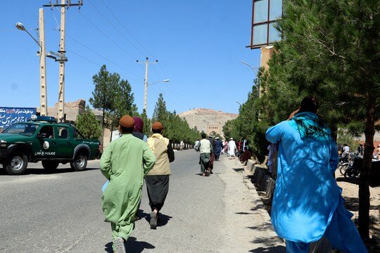 Afghan people run near the site of an explosion in Herat province, Afghanistan, Friday, Sept 2, 2022