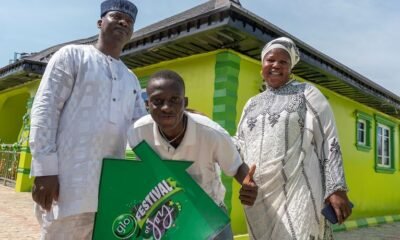 Ibrahim Akindele poses with a Glo Festival of Joy banner