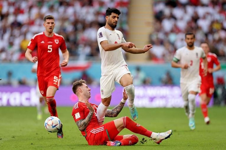 Wales' Joe Rodon in action with Iran's Mehdi Taremi