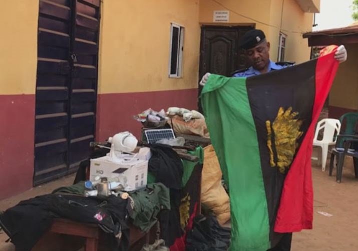 A policeman holding up an IPOB flag after the bust in Ebonyi State