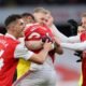 Arsenal players celebrate with match winner Reiss Nelson