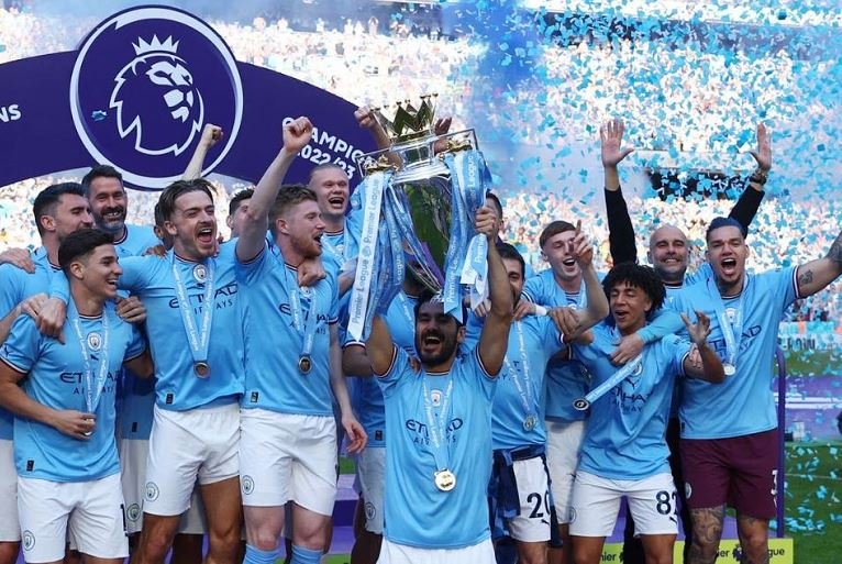 Manchester City's Ilkay Gundogan lifts the trophy as he celebrates with teammates after winning the Premier League
