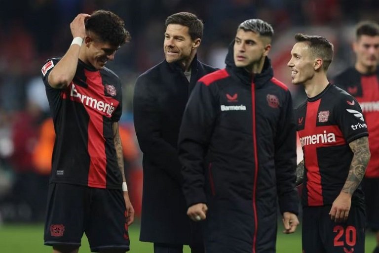 Bayer Leverkusen coach Xabi Alonso celebrates with Alejandro Grimaldo and Piero Hincapie after the match REUTERS