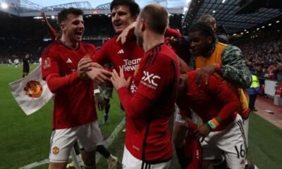 Manchester United players celebrate with Amad Diallo after he scored the winner