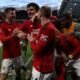 Manchester United players celebrate with Amad Diallo after he scored the winner