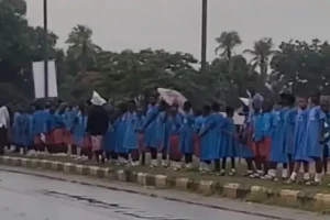 Children stand in the rain singing anthem as Tinubu’s convoy arrives in Benue