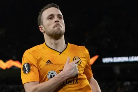 Diogo Jota touches the Wolves badge in celebration