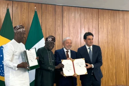 Nigerian and Brazilian officials holding signed bilateral agreements during a diplomatic meeting.